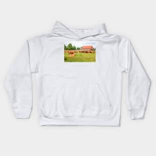 A herd of brown simmental cows grazing on a green pasture Kids Hoodie